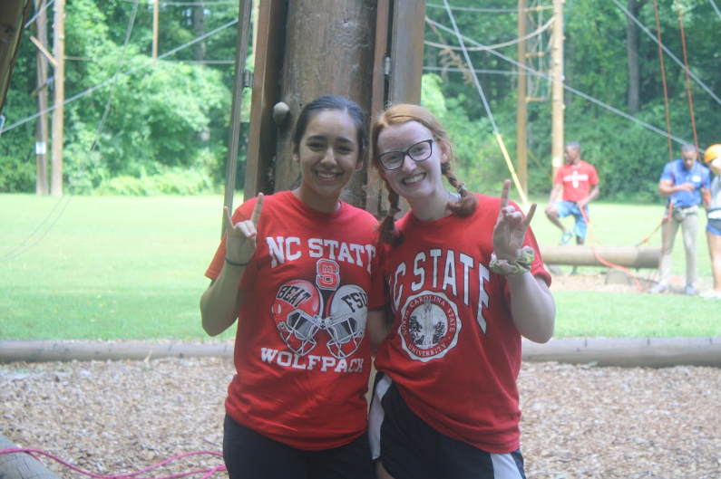 Two students in NC State tshirts in front of a ropes course