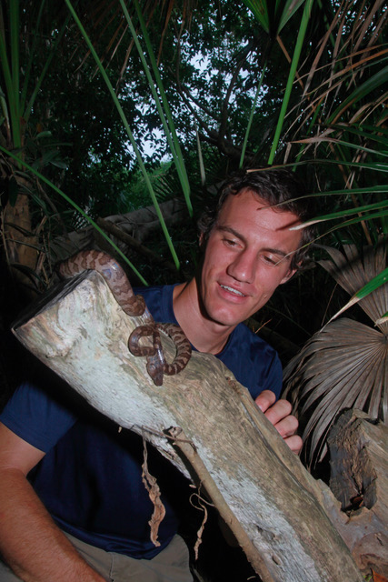 Sam in the jungle with a snake on a branch